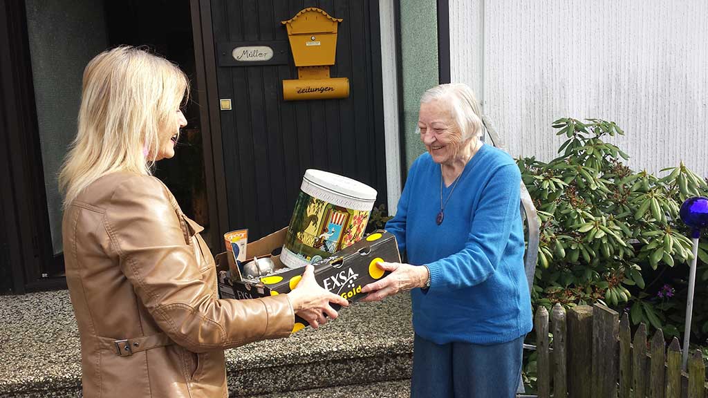 Die ehemalige Herbergsmutter der Rintelner Jugendherberge, Frau Müller, überreicht gerade Lydia Wallenstein eine Kiste mit "Schätzen" für die Versteigerung.