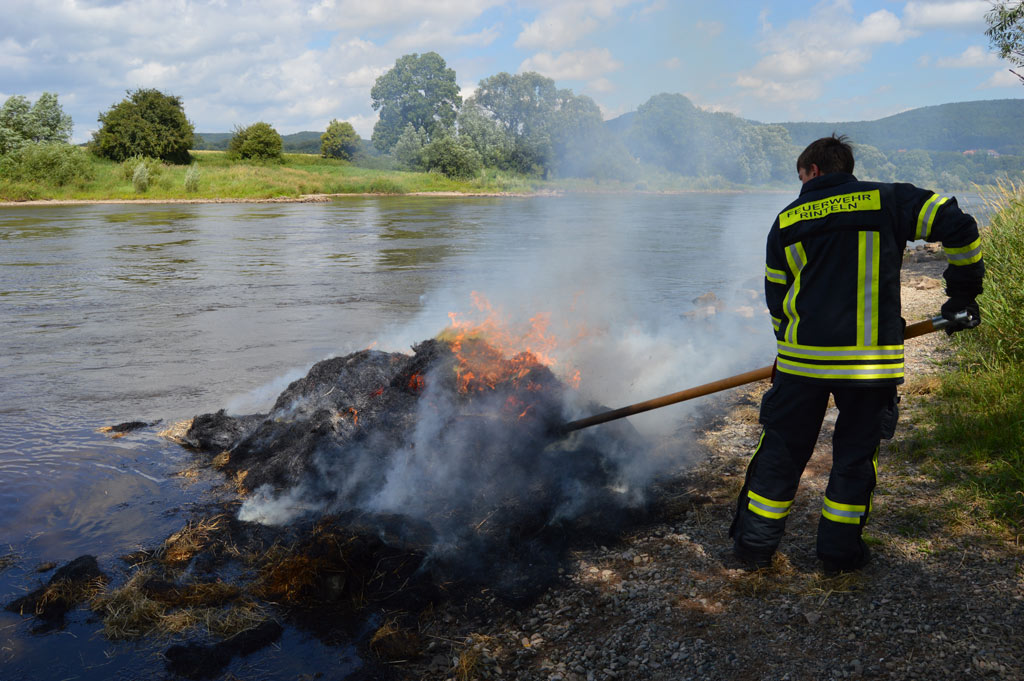 Der brennende Strohballen wurde auseinander gerissen und durch das Weserwasser gelöscht